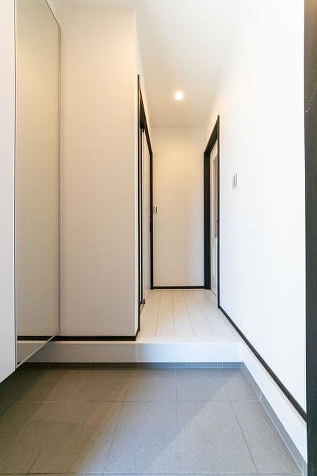 「ただいま」の声が響く開放的なホール。白を基調とした内装が、一日の疲れをリセットし、家族の団らんへと優しく導きます。