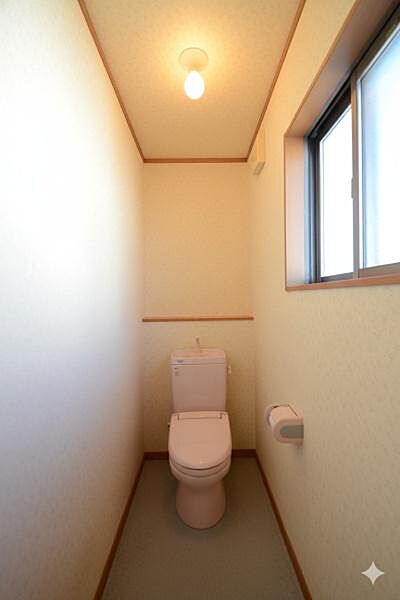 窓から自然光が差し込む、明るく清潔感のあるトイレ空間です。換気がしやすく、掃除もスムーズに行える実用的な設計です。