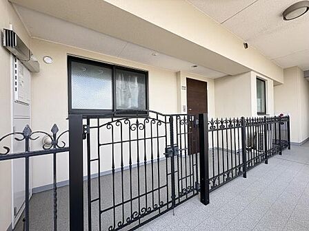 アイアン調の門扉を備えた専用ポーチ付き玄関。住戸の独立性とプライバシーを高め、共用廊下から室内が見えにくく、防犯面にも配慮。ゆとりと上質感を演出する、特別感のある玄関まわりです。