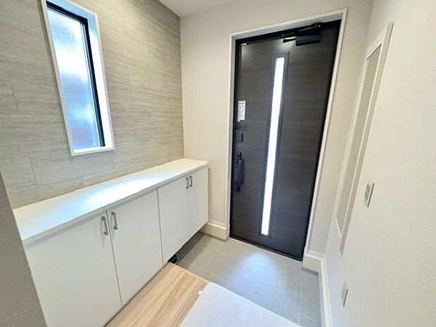 白を基調とした清潔感のある玄関空間です。収納も十分確保されておりますので大家族でも困りませんね！全身の身だしなみチェックもできる姿見もございます！