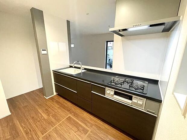 落ち着いた色合いのスタイリッシュなキッチン。広いワークトップと収納で調理も快適、リビングとの一体感で家族との会話も弾みます。