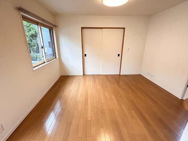 キッチンに隣接したリビングスペース。明るい床色とアクセントクロスが調和した、落ち着きのある心地よい空間です。