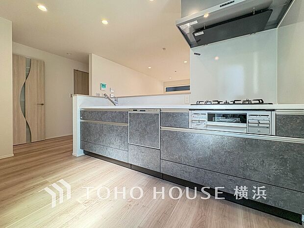 機能性とデザイン性を兼ね備えたシステムキッチン。リビングとの一体感も考慮され、美しい空間が実現。