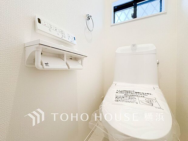 トイレはシンプルにホワイトで統一。多機能型の温水洗浄付き。 1号棟 