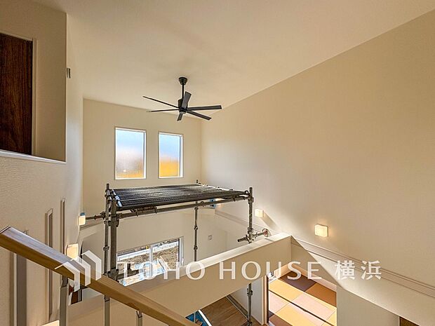 天窓から降り注ぐ自然光が、吹抜けの開放的な空間を照らします。穏やかな光に包まれた上質な居住空間です。