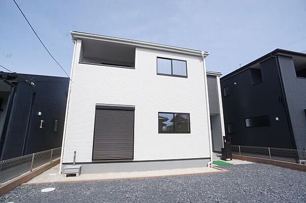 駐車場と一体化した砂利と土仕様の庭。