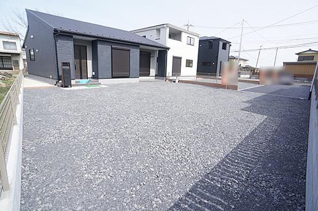 駐車場と一体化した砂利と土仕様の庭。