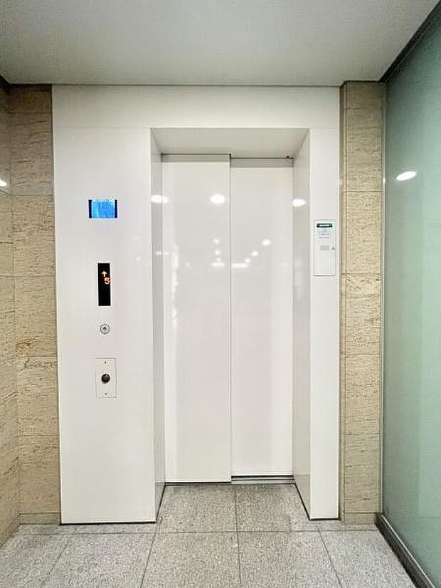 オシャレな白色のエレベーター！中に乗っている人が確認できるモニターが備わっており、防犯性が高い！