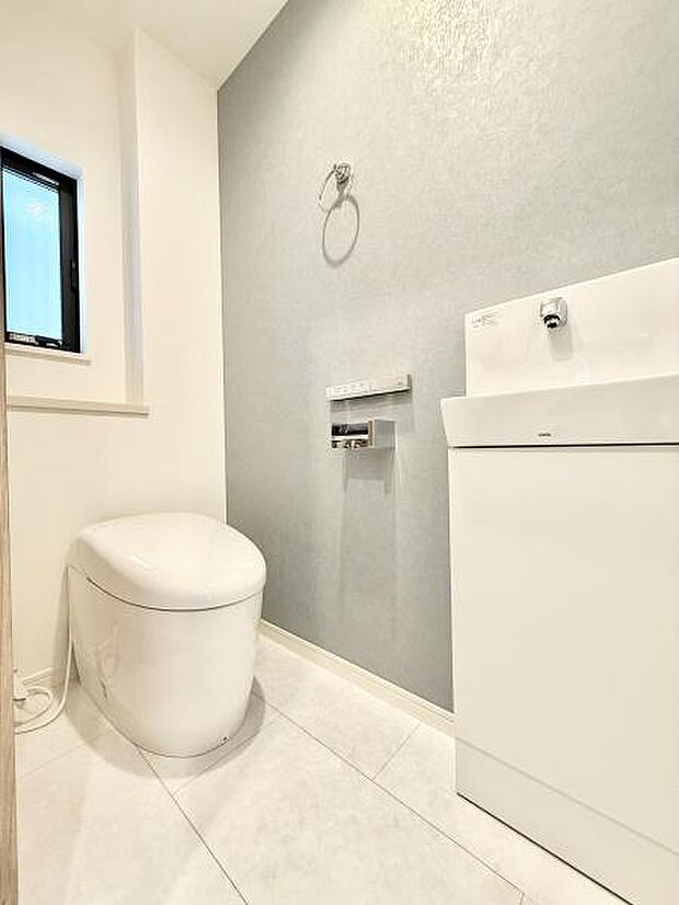 小窓付きで換気性も良くアクセントクロスが空間に程よい締まりを与えています。タンクレストイレはお掃除がしやすくスマートな印象！手洗い場付きで広さもあり、清潔感と機能性を兼ね備えた仕様です。