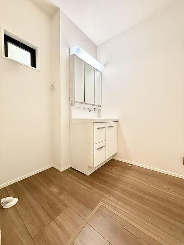 三面鏡付き洗面化粧台。合わせ鏡で後ろのスタイリングも快適。鏡の後ろは収納になっているので、細々したものを収納でき、スッキリとした洗面回りに。