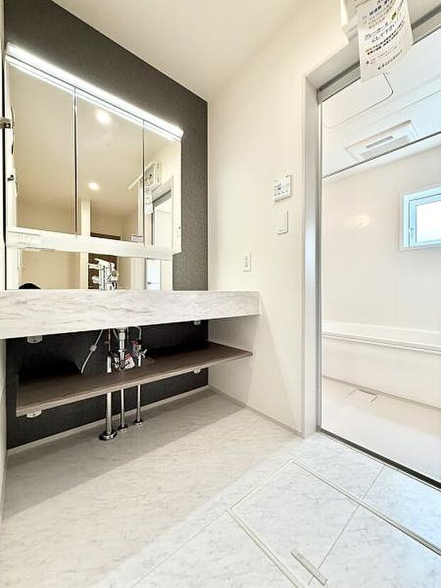 三面鏡付き洗面化粧台。合わせ鏡で後ろのスタイリングも快適。鏡の後ろは収納になっているので、細々したものを収納でき、スッキリとした洗面回りに。