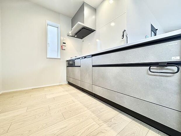 清潔感溢れるシステムキッチンは、広々としたカウンタースペースでお料理もスムーズ。三口コンロとシンクが効率的に配置されており、家事がはかどります。