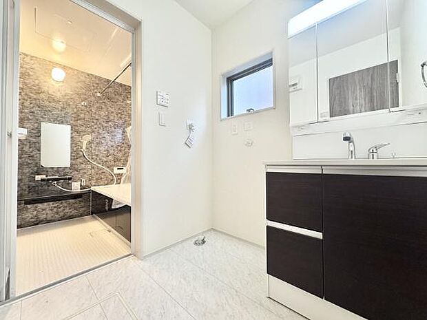 三面鏡付き洗面化粧台。合わせ鏡で後ろのスタイリングも快適。鏡の後ろは収納になっているので、細々したものを収納でき、スッキリとした洗面回りに。