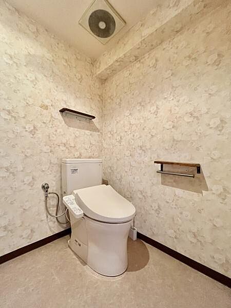 ゆとりある広さを確保したトイレ空間。温水洗浄便座付きで快適にご利用いただけます。落ち着いたクロスが空間をやさしく演出し、毎日気持ちよくお使いいただける清潔感のある空間です。