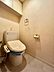トイレ：温水洗浄機能付きのトイレ。上部には収納棚を備えており、トイレットペーパーや掃除用品などをすっきり収納できます。床材も張替えられており、清潔感のある空間に仕上がっています。