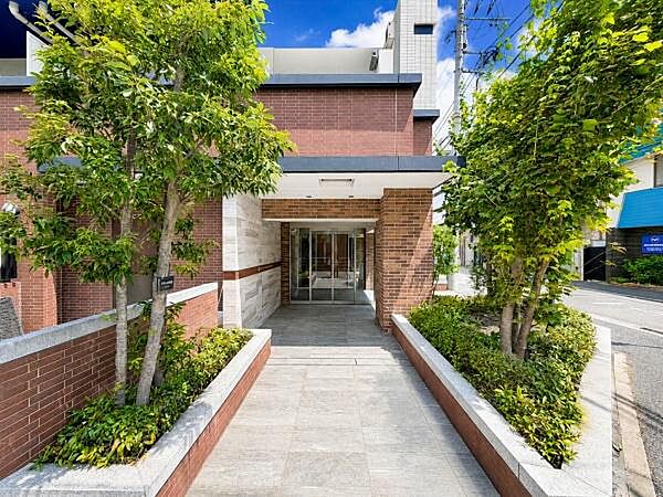 植栽の緑と重厚感あるレンガ調の外壁が迎えるエントランスアプローチ。落ち着いた雰囲気と清潔感があり、住まう方や訪れる方を上品に迎えてくれる、マンションの第一印象を高める空間です。