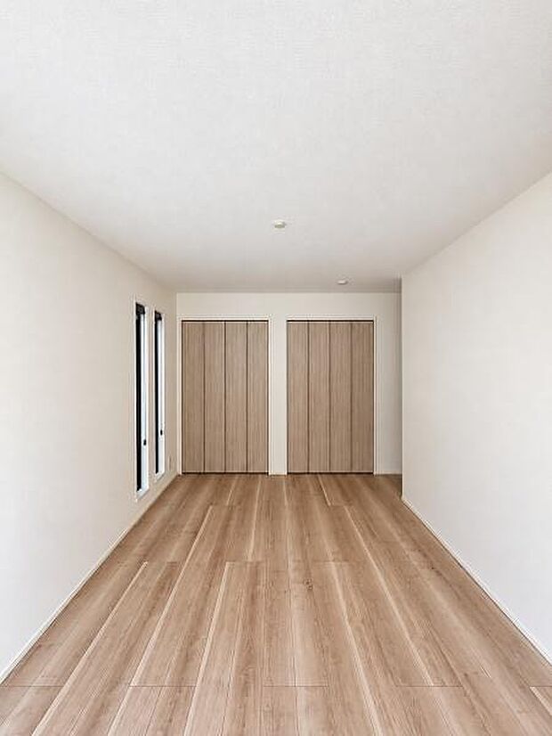 白い壁と木目の床が調和する、落ち着いた雰囲気の洋室。壁面にクローゼットを備え、収納家具を増やさずにお部屋を整えられます。ベッドや学習机など、ご家族の暮らしに合わせた家具配置を考えるのも楽しみです。