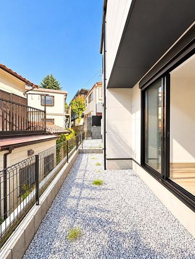 建物脇にはゆとりあるスペースを確保。窓から室内へ光を取り込みやすく、外まわりにも開放感があります。砂利敷きで管理もしやすく、自転車置場やちょっとした屋外スペースとしても活用しやすい空間です。