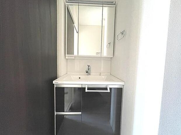 三面鏡付き洗面化粧台。合わせ鏡で後ろのスタイリングも快適。鏡の後ろは収納になっているので、細々したものを収納でき、スッキリとした洗面回りに。