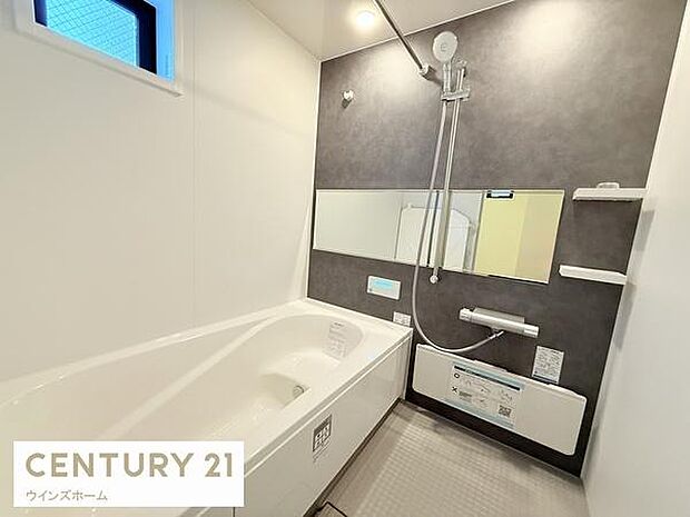 小窓付きで換気しやすい明るいバスルーム。浴室乾燥暖房機を備え、雨の日の洗濯にも便利。ゆったりとした浴槽で一日の疲れを癒せる、清潔感ある空間です。