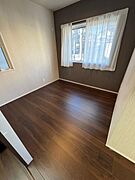落ち着きのあるフローリングが広がる洋室です。二面採光で明るさがしっかりと確保されています。シンプルなデザインがどんなインテリアにも合わせやすい空間を提供します。