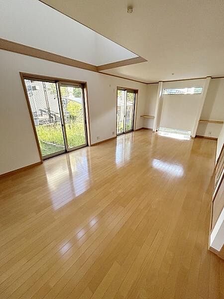 大きな窓からたっぷりと自然光が差し込むリビングです。開放感のある空間が魅力的です。明るい床が室内を広々と見せています。天井の高い設計が快適な印象を与えます。すっきりとした内装が特徴です。