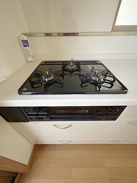 3口コンロが備わっており複数のお料理もスムーズに調理できます。シンプルなデザインで清掃もしやすい仕様です。キッチン周りがすっきりまとまっていて使い勝手が良いです。収納スペースも十分に確保されています。
