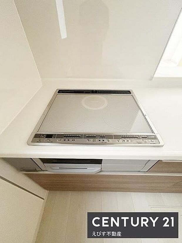 シンプルで清潔感のあるキッチンです。IHクッキングヒーターが設置されています。調理スペースもゆったりしています。お手入れがしやすいデザインが特徴です。