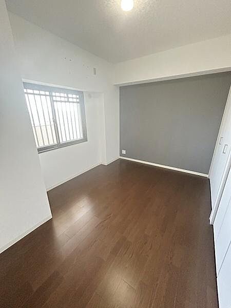 明るい窓から自然光が差し込む子供部屋です。落ち着いたフローリングで清潔感があります。壁面はシンプルで使いやすく収納スペースも充実しています。