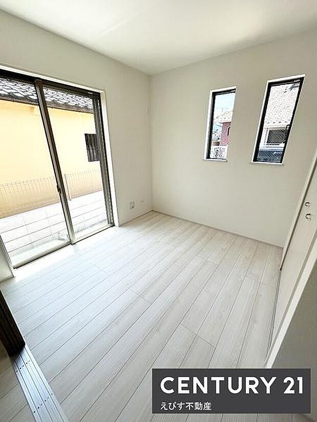 1階リビング横洋室約4.5帖。二面採光で室内が明るくなります。ホワイト系の床材で空間に広がりを感じます。洋室ならではのシンプルな仕上がりです。室内の清潔感が印象的です。