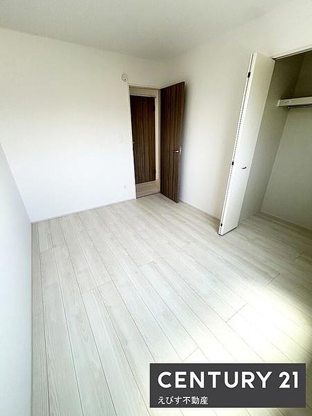 明るいフローリングが特徴の洋室です。クローゼットも備え付けられており収納スペースが確保されています。シンプルな内装なのでインテリアの自由度も高いです。ドアやクローゼットの色調が落ち着いています。