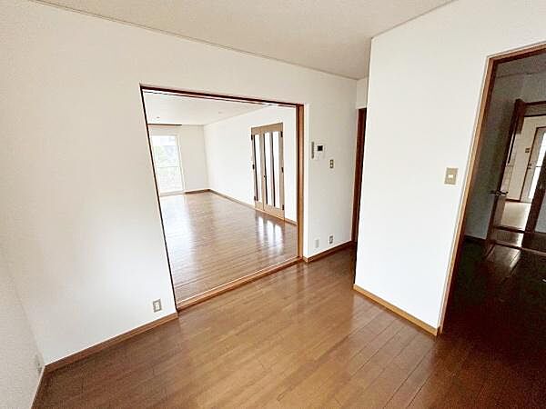 開放的な空間が広がる室内は明るさを感じられる設計になっています。複数の部屋がつながる間取りで用途に合わせた使い分けが可能です。木目調のフローリングが落ち着いた雰囲気を演出しています。