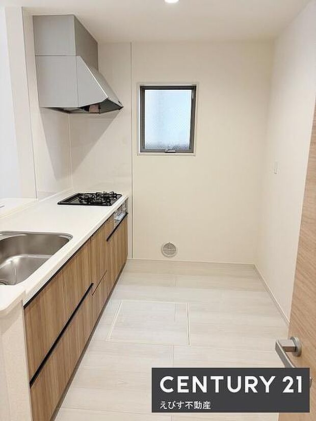 料理や片付けなどの家事動線の良いキッチン。窓があり自然光が差し込みます。木目調の収納で温かみを感じられます。落ち着いた色合いが空間に調和しています。