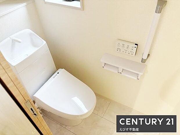 シンプルなデザインでまとまったトイレ空間です。手洗い一体型でスペースを有効活用できます。壁に操作パネルと手すりが設置されており機能性も備わっています。清潔感のある明るいトーンの内装です。