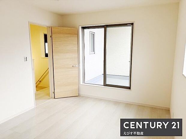 明るい日差しが差し込む洋室です。シンプルな色合いの壁と床で幅広いインテリアにマッチします。奥にはバルコニーへ出入りできる大きな窓があります。清潔感のある空間が魅力です。