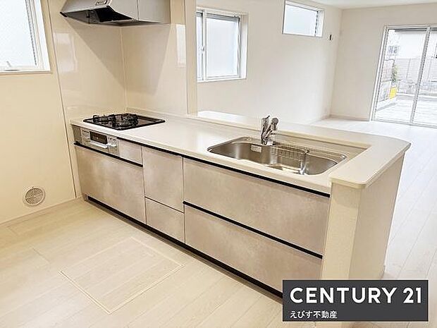 シンプルなデザインのキッチンが空間をすっきりと見せています。十分な収納スペースがあり作業スペースも広く確保されています。複数の窓から光が入るのでキッチン全体が明るい印象です。全体的に清潔感があります。