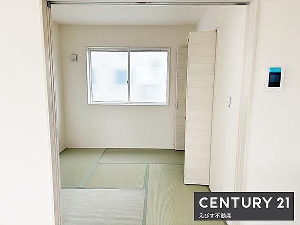 明るい光が差し込む落ち着いた雰囲気の和室です。清潔感のある白い壁と畳の組み合わせが魅力的です。収納スペースもしっかり備えられておりすっきりとした空間が広がります。