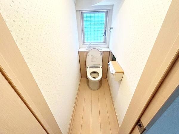 【一部AIモノ消し済み・実際の室内状況優先】明るい窓付きのトイレで換気もしやすい空間です。ペーパーホルダーとタオル掛けが使いやすい位置に配置されています。