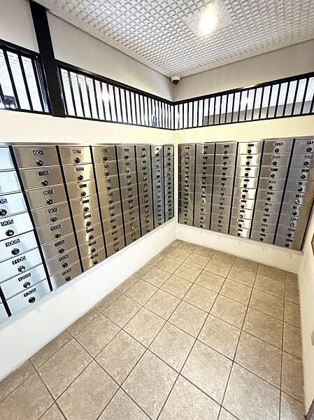 各住戸ごとに専用の郵便ポストが設置され管理がしやすい造りです。明るい照明と清潔感のあるタイル床で快適に利用できます。窓からの採光もあり屋内でも圧迫感のない空間です。防犯カメラも設置されていて安心です。