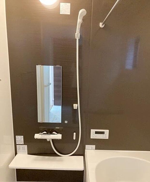 浴室にはシンプルで使いやすいシャワーが設置されています。壁面は落ち着いた色合いで清潔感があります。鏡や小物置き場も備わっています。コントロールパネルで操作も便利です。