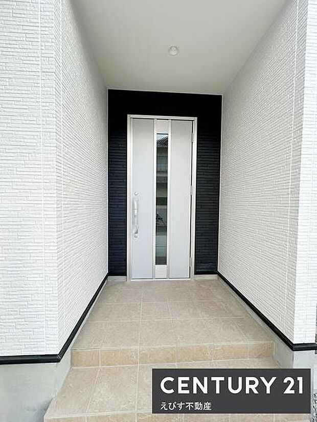 シンプルで落ち着いたデザインの玄関です。白を基調とした外壁とモダンなドアが印象的です。段差の少ないアプローチで使い勝手にも配慮されています。上部もゆとりある空間になっています。