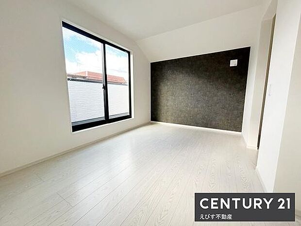 大きな窓から光が差し込む明るい寝室です。落ち着いた色合いのアクセントクロスが空間にメリハリを与えています。シンプルな内装は幅広いインテリアに対応できます。ゆとりのあるスペースで快適に過ごせます。