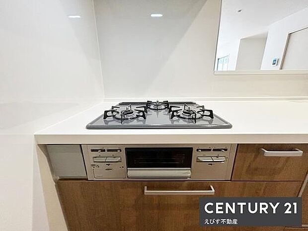 シンプルで使いやすいキッチンです。ガスコンロが3口あり調理の幅が広がります。使い勝手の良い収納も備わっています。清潔感のある仕上がりです。空間の印象を明るくしています。