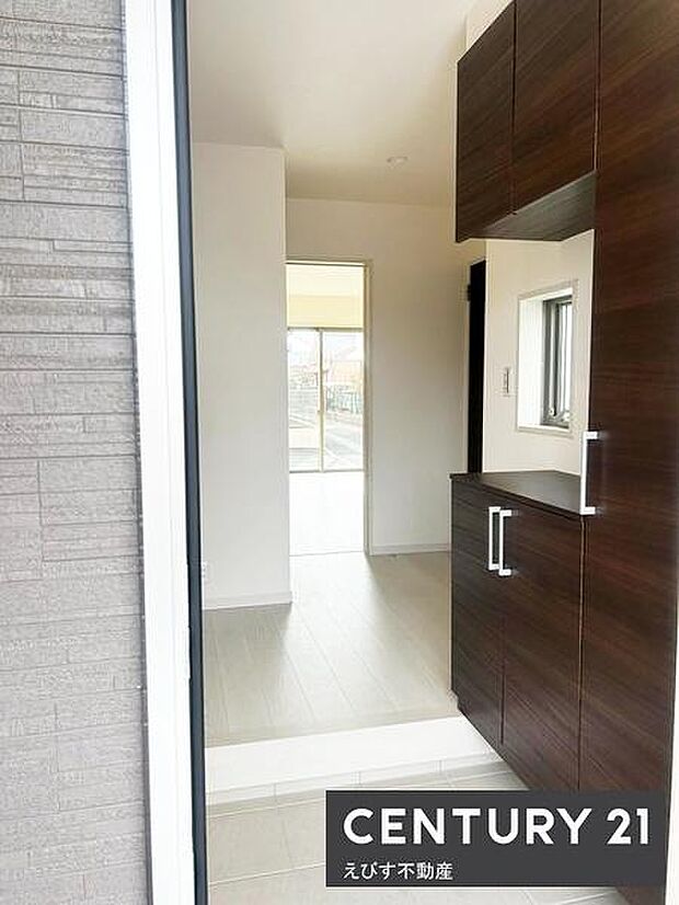 落ち着いた色合いの玄関収納が印象的です。明るい光が差し込むスペースで開放感があります。窓付きで換気もしやすく爽やかな第一印象を与えます。収納力のあるシューズボックスが使いやすそうです。