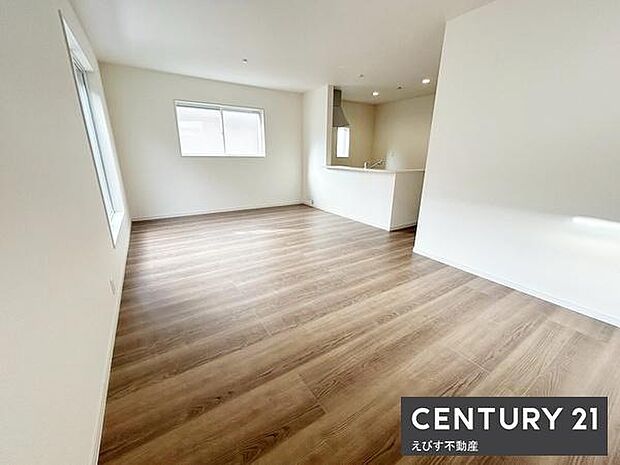 リビングは白を基調とした壁と明るい木目の床で広々とした空間が広がっています。二面に窓があるため日中は自然光がたっぷり差し込みます。キッチンとのつながりも良く開放感を感じられます。