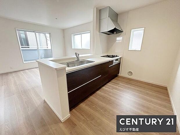 キッチンは明るい空間で開放的なデザインが特長です。シンプルな色合いで清潔感があります。窓が複数あり採光も十分です。床は木目調でお手入れもしやすそうです。