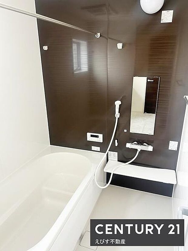 落ち着いた色合いの壁面が印象的なバスルームです。雨の日のお洗濯にも大活躍な浴室乾燥機有り。浴槽の形状もゆったりとした印象を与えます。窓から自然光が差し込みます。清潔感のある空間です。