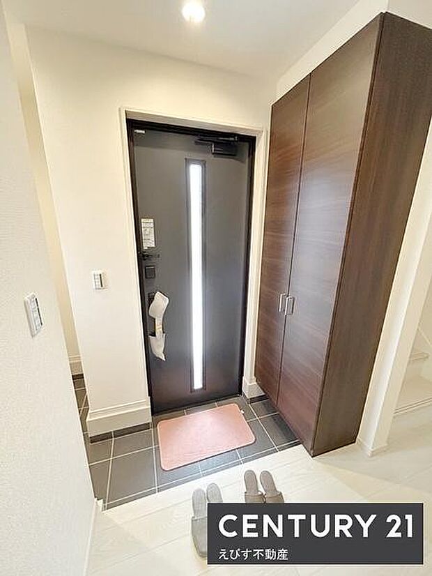 清潔感のある玄関スペースです。収納が備え付けられており整理整頓しやすくなっています。シンプルなデザインで使い勝手が良い印象です。明るい印象を与える照明もポイントです。