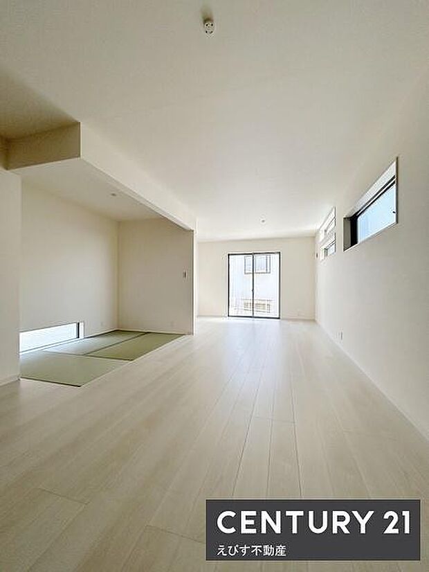 リビングは明るい色のフローリングが広がり空間に開放感があります。隣接する和室がアクセントとなり落ち着いた雰囲気が漂います。大きな窓から自然光が差し込み室内を明るく演出しています。