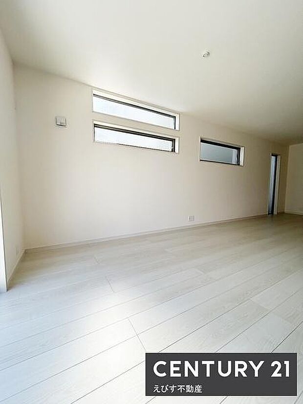 明るい印象の洋室です。大きな窓から光が差し込み室内が開放的に感じられます。床は落ち着いた色合いでシンプルな内装が特徴です。家具の配置もしやすい空間になっています。